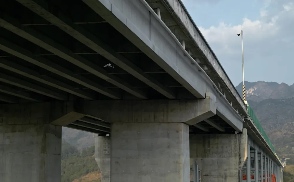 DJI Matrice 4 inspecting the underside of a concrete bridge deck