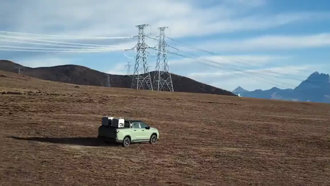 A vehicle-mounted DJI Dock 3 on open ground beneath a transmission line