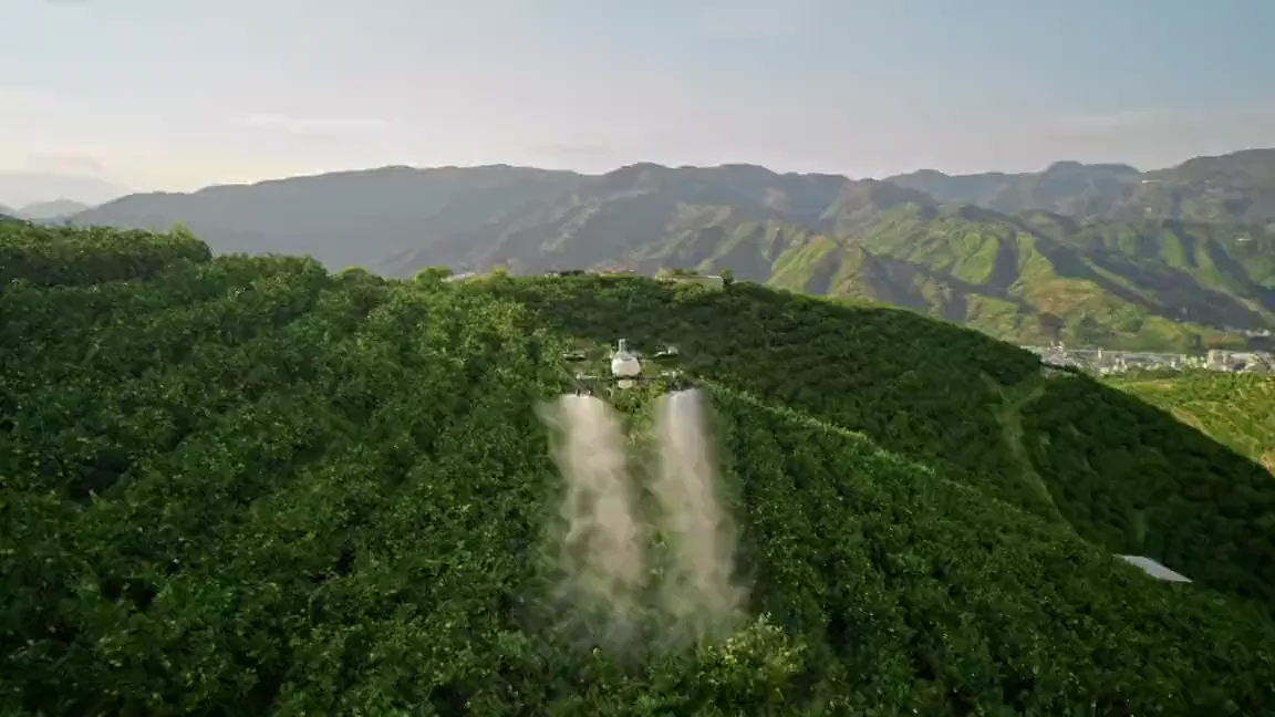 DJI Agras T55 spraying over green hills