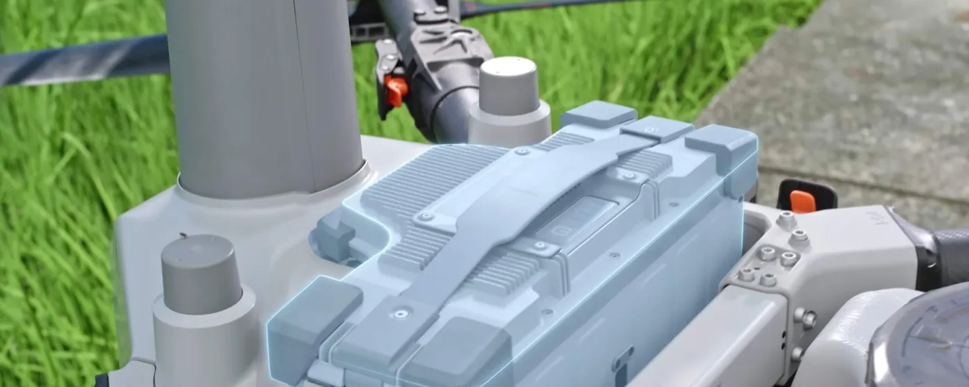 Close-up of the battery bay and pump housing on a DJI Agras spraying drone